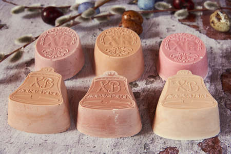 Delicate handmade Easter soap, painted eggs and willow branches on a textured surface.の写真素材