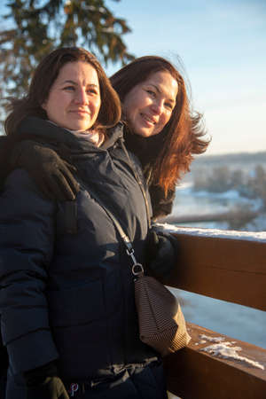 Russia, Moscow region, December 2020. Two friends pose on the veranda on a sunny winter day.のeditorial素材