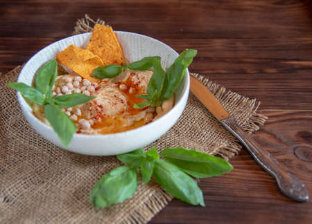 Chickpea hummus in a deep dish on a wooden countertop. Food backgrounds, copy space for text.の写真素材