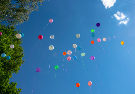 Colorful inflatable balloons rise into the bright blue sky.の写真素材