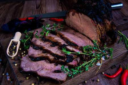 Roast beef on cutting board. Wooden background. Close up.の写真素材