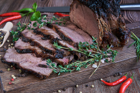 Roast beef on cutting board. Wooden background. Close up.の写真素材
