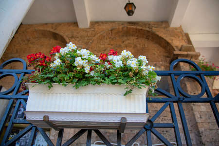 A balcony decorated with planters with bright multicolored begonias.の写真素材