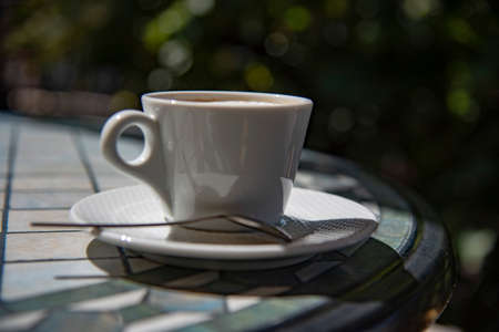 A cup of cappuccino on a table in a summer cafe on a sunny day.の写真素材