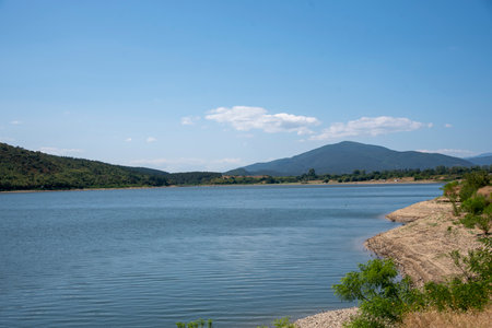 View of the blue lake against the background of the mountains on a clear sunny summer day.の写真素材