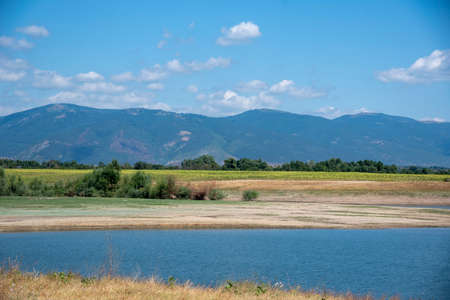 View of the blue lake against the background of the mountains on a clear sunny summer day.の写真素材