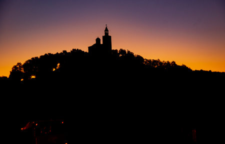 The black silhouette of an ancient tower on a mountain against the sunset background.の写真素材