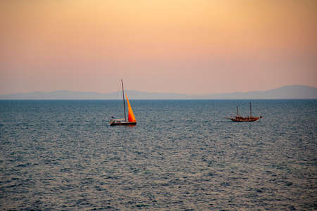 Sailboat in the sea in the evening sunlight over sky background. Luxury summer adventure or active vacation concept. Copy space.の写真素材