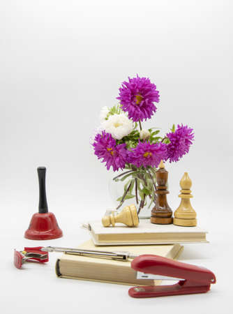 A composition of flowers in a vase, books and various educational accessories on a light background. Congratulations on the teacher's day.の写真素材