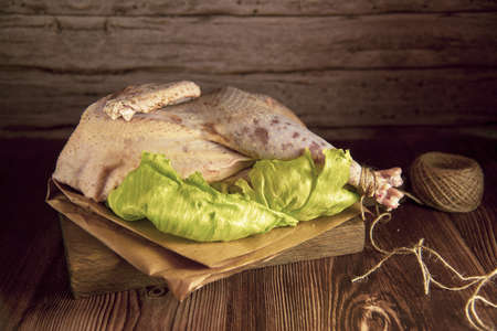 Fresh raw meat. The chicken carcass lies on bright green salad leaves with vegetables and seasonings.の写真素材