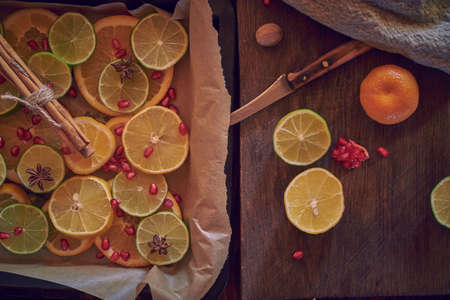 A baking tray with chopped citrus fruits and a cutting board with a knife. Food background.