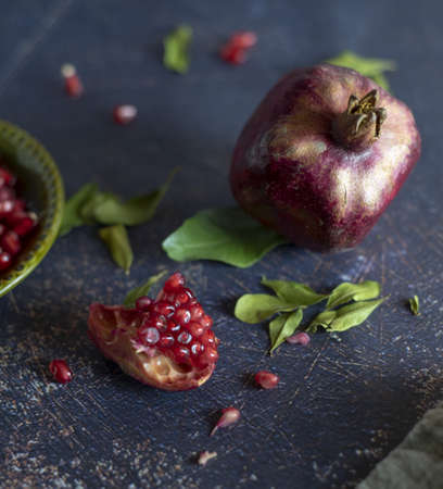 Ripe pomegranate and pomegranate leaves on a dark background.Food background.の写真素材