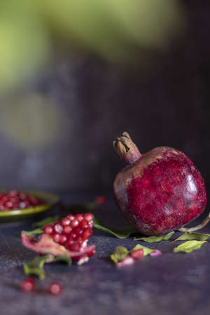 Ripe pomegranate and pomegranate leaves on a dark background.Food background.の写真素材