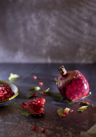 Ripe pomegranate and pomegranate leaves on a dark background.Food background.の写真素材
