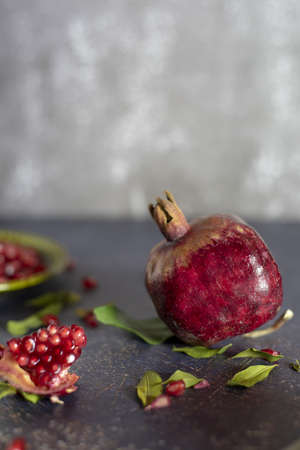 Ripe pomegranate and pomegranate leaves on a gray background.Food background.の写真素材