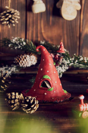 A house in the shape of a fly agaric, made with your own hands and a New Year's decor on a wooden countertop.の写真素材
