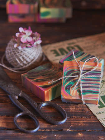 Fragrant multicolored handmade soap, antique scissors and jute threads on wrapping paper.の写真素材