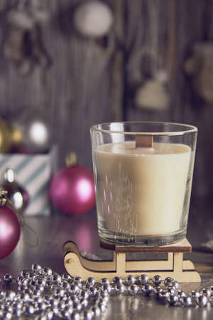 A fragrant handmade candle made of soy wax on the background of a New Year's decor.の写真素材