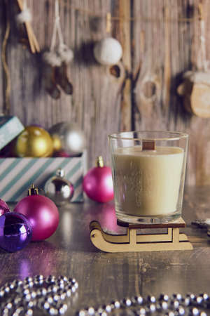 A fragrant handmade candle made of soy wax on the background of a New Year's decor.の写真素材
