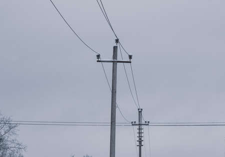 Transmission towers and power lines against a gloomy cloudy sky.の写真素材