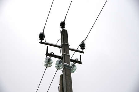 Transmission towers and power lines against a gloomy cloudy sky.の写真素材