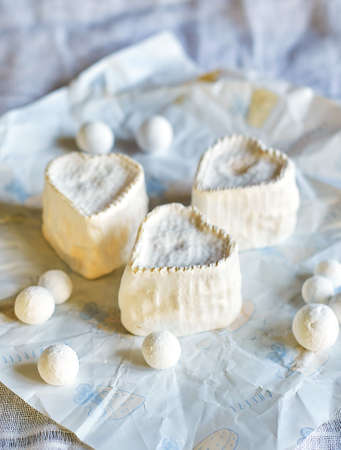 Heart-shaped cheese with white mold on wrapping paper. Home production, natural products.の写真素材