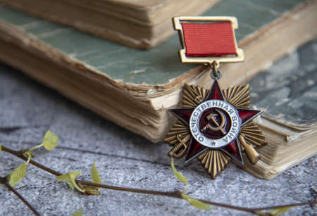 Russia, Moscow, February 2022. Victory Day May 9 holiday background composition, Soviet order , Second World war, books,birch branches. Copy space, postcard.のeditorial素材