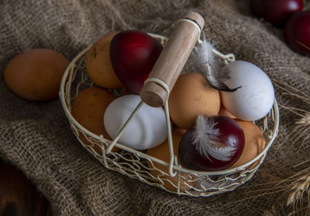 Vintage basket with eggs. Natural and dyed Easter eggs.の写真素材