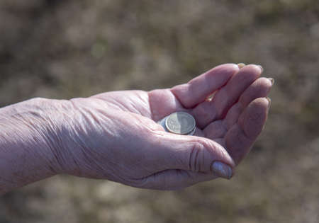 Russian coins in the wrinkled hands of an elderly woman.の写真素材