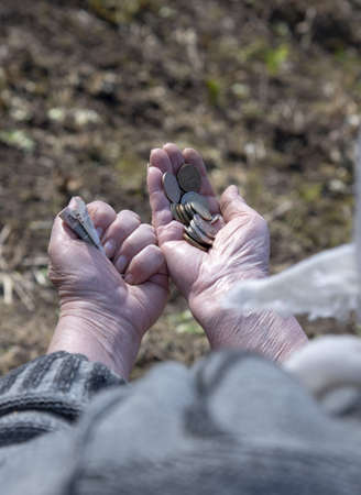 A pensioner woman counts small money in her hands.の写真素材