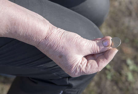 Russian coins in the wrinkled hands of an elderly woman.の写真素材