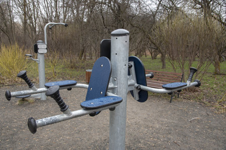 Stationary outdoor fitness simulator in a public park on a cloudy rainy day.
