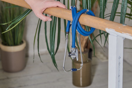 The stethoscope hangs on a wooden crossbar in the doctors office, decorated with fresh flowers.の写真素材