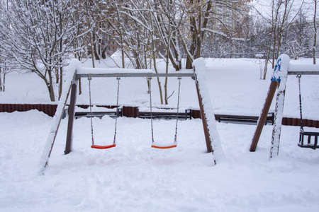 An empty playground in the snow in a public park.の写真素材