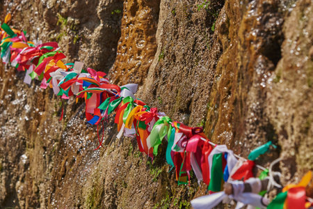 Bright silk ribbons are tied in a knot at the Maiden's Tears waterfall in Abkhazia. selective focus.の写真素材
