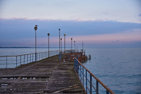 A pier stretching far into the sea against the backdrop of a beautiful sunset.の写真素材