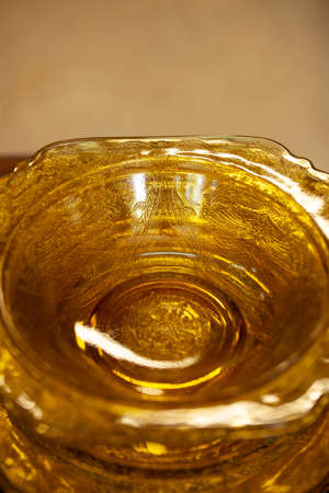 table setting with an antique glass service with a filigree pattern. yellow glass service in the interior. vintage service close-upの写真素材