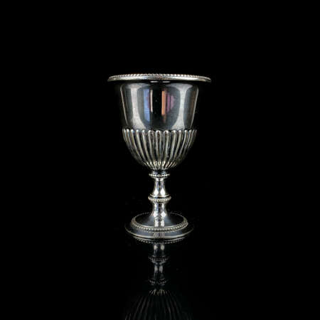 antique metal glass. antique silver glass for alcoholic beverages. engraved silver service on a black isolated backgroundの写真素材