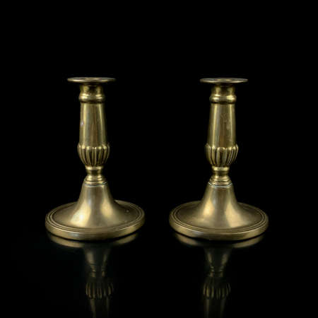 copper antique candlestick with burning candles. vintage golden candlestick on black isolated backgroundの写真素材