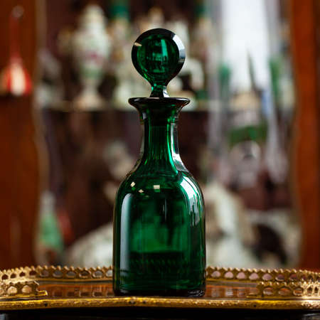 set of glass green bottles in luxury interior. crystal green bottle. bohemian glass closeupの写真素材