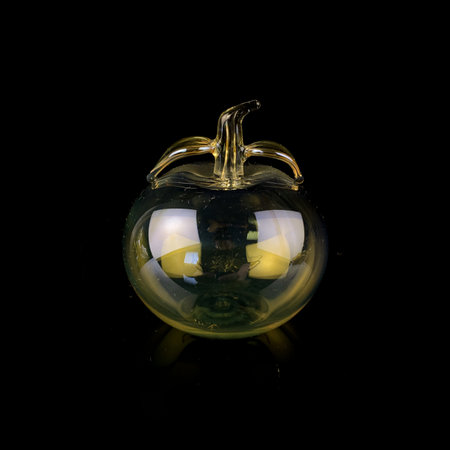 glass yellow apple on a black isolated background. antique figurine of an appleの写真素材