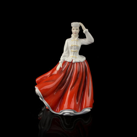 Ceramic statuette of a woman on a black background. antique figurine of a woman in a retro dressの写真素材