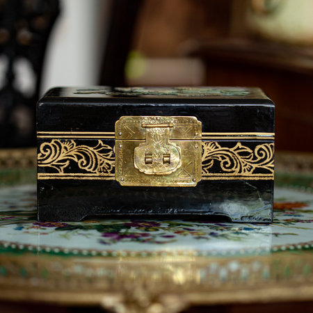 Old black box with gold pattern on the table, close-up. gold antique boxの写真素材