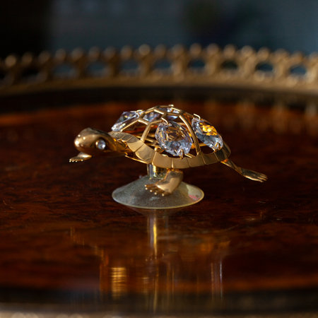 jewelry ring in the form of a bird on a mirror. antique gold figurine of a turtle in a luxurious interior.の写真素材