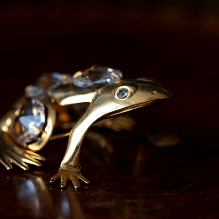 Jewelry on a wooden background. Jewelry in the form of a frog. golden antique figurine of a toad in a luxurious interior.の写真素材