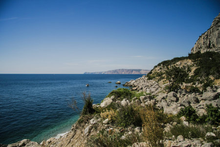 Bright blue sea and rocks and forest on a sunny day in the Crimeaの写真素材