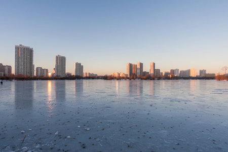 Frozen lake reflecting buildings and skyの写真素材
