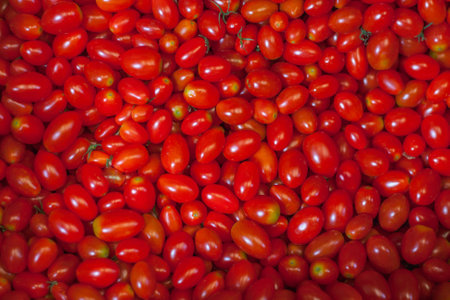 Pile of many fresh red cherry tomatoes. Delicious raw healthy food background. Vegetable market in Bangkok, Thailandの写真素材