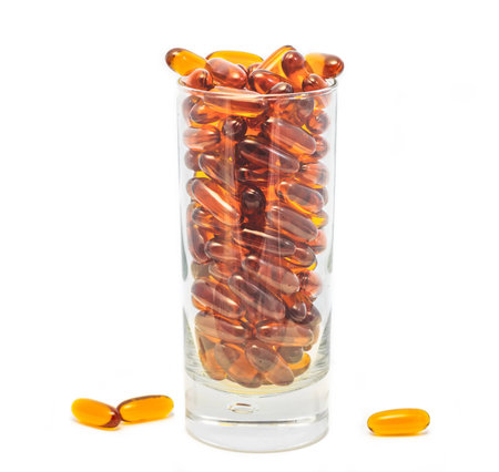 Lecithin gel pills in a glass isolated on a white background. Soy and sunflower lecithin. Vitamin supplement gelatin capsules. Studio shotの写真素材