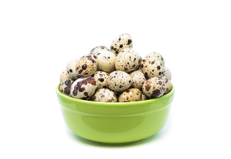Quail eggs in a green bowl isolated on white background cutout. Studio shotの写真素材